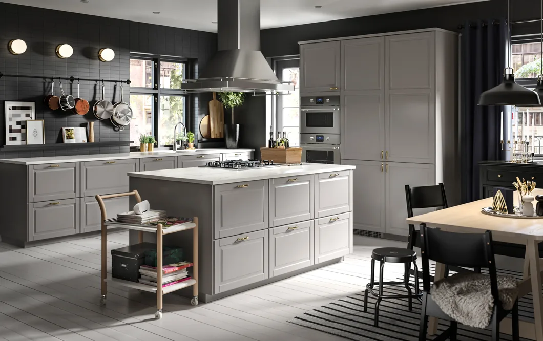 A large grey and black kitchen with an island in the centre.