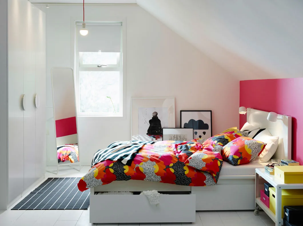 A white and pink bedroom with a white MALM bed and multicolour TOFSVIVA bed linen.